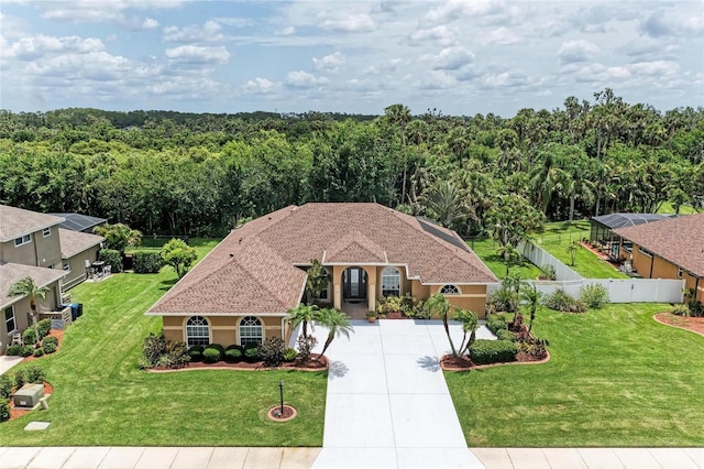 5359 90th Avenue Cir E, Parrish, FL 34219 - view of front of home with driveway, an attached garage, stucco siding, and a wooded view