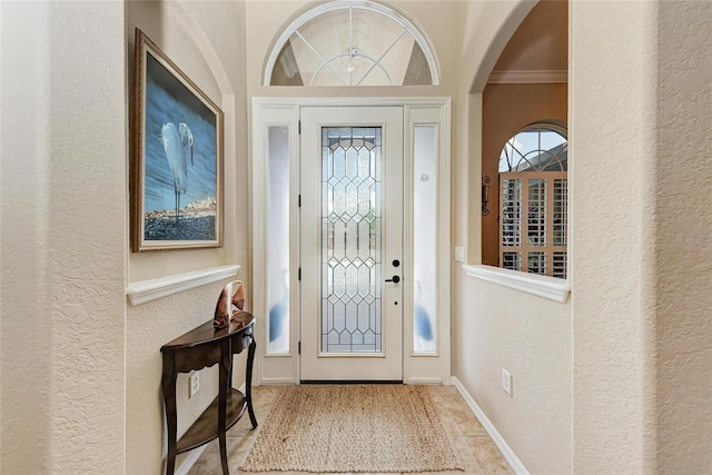 5359 90th Avenue Cir E, Parrish, FL 34219 - foyer featuring a textured wall, ornamental molding, arched walkways, and baseboards
