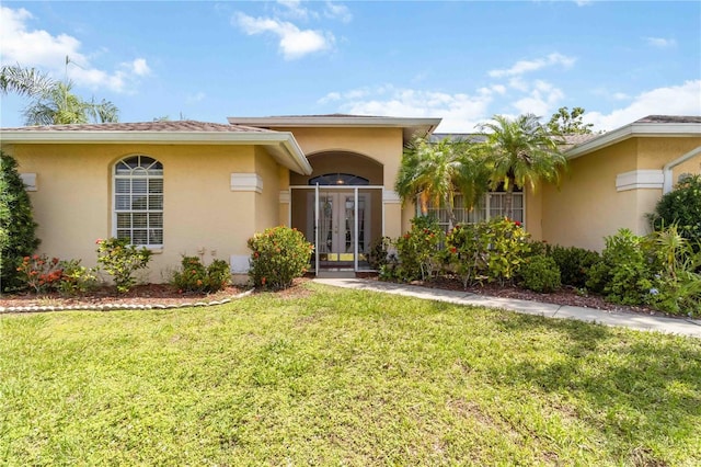 6405 Alesheba Ln, Sarasota, FL 34240 - view of front facade with stucco siding, french doors, and a front lawn