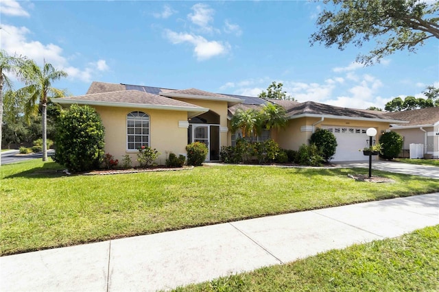 6405 Alesheba Ln, Sarasota, FL 34240 - single story home featuring stucco siding, roof mounted solar panels, a garage, driveway, and a front lawn