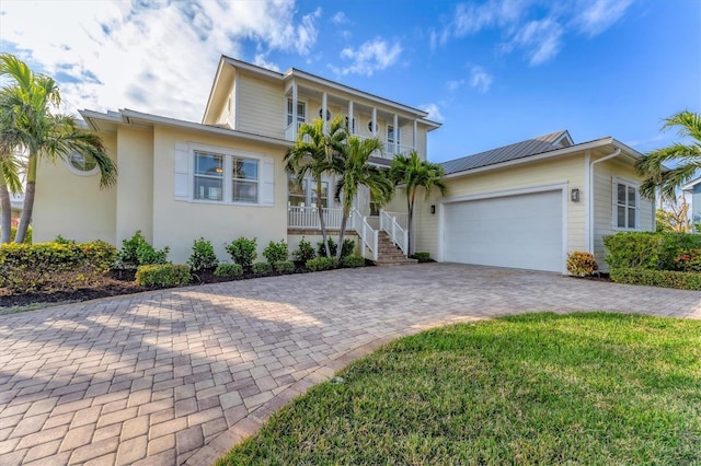 634 Key Royale Dr, Holmes Beach, FL 34217 - view of front facade featuring a porch, a garage, driveway, and stucco siding