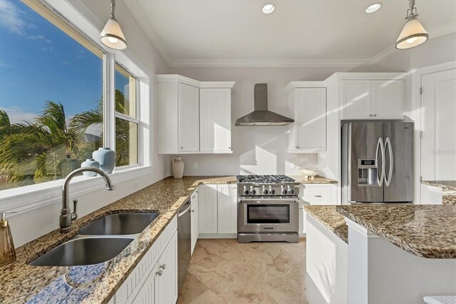 634 Key Royale Dr, Holmes Beach, FL 34217 - kitchen featuring appliances with stainless steel finishes, wall chimney exhaust hood, a sink, white cabinets, and pendant lighting