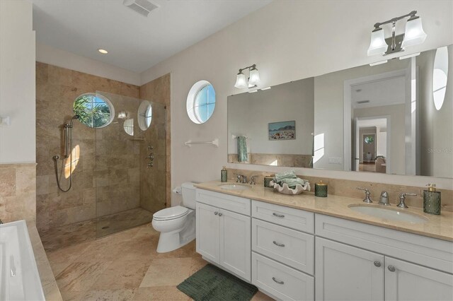 634 Key Royale Dr, Holmes Beach, FL 34217 - bathroom featuring double vanity, healthy amount of natural light, a tile shower, and toilet