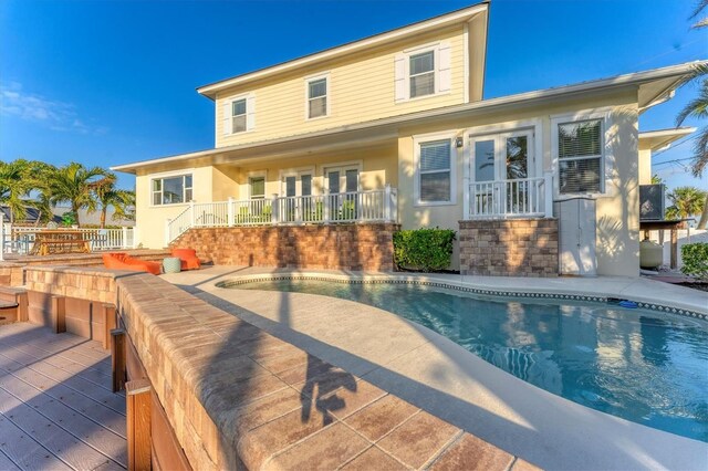 634 Key Royale Dr, Holmes Beach, FL 34217 - back of house featuring french doors, an outdoor pool, and stucco siding