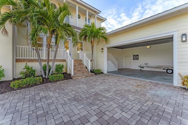 634 Key Royale Dr, Holmes Beach, FL 34217 - view of front facade featuring decorative driveway, a garage, stairs, and a porch