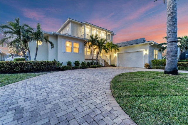 634 Key Royale Dr, Holmes Beach, FL 34217 - view of front of home featuring a garage, decorative driveway, stucco siding, and a front yard