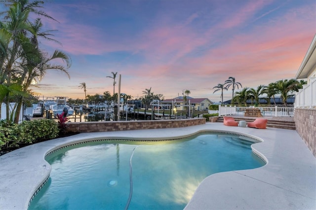 634 Key Royale Dr, Holmes Beach, FL 34217 - pool at dusk featuring an outdoor pool, boat lift, and a boat dock