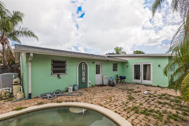 225 Sherwood Ln, Daytona Beach, FL 32117 - back of property with french doors, concrete block siding, a patio area, and an outdoor pool
