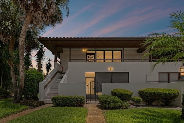 3500 El Conquistador Pkwy Unit 132, Bradenton, FL 34210 - view of front of house featuring a gate, stairway, stucco siding, a balcony, and a tiled roof