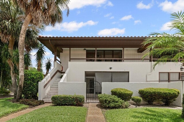 3500 El Conquistador Pkwy Unit 132, Bradenton, FL 34210 - view of front of property featuring stairs, a fenced front yard, stucco siding, a gate, and a tile roof