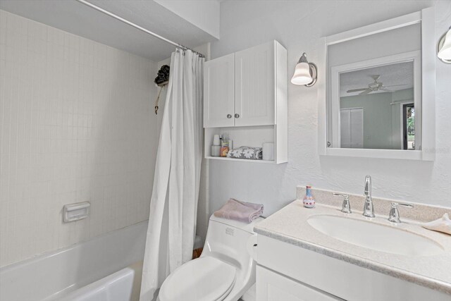 3500 El Conquistador Pkwy Unit 132, Bradenton, FL 34210 - bathroom featuring vanity, shower / bath combo with shower curtain, toilet, a ceiling fan, and a textured wall