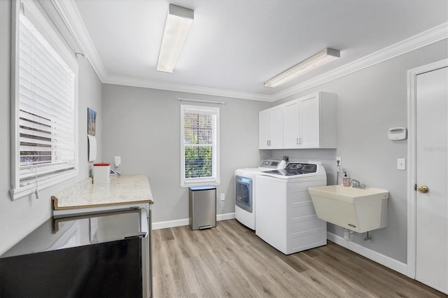 2005 21st St W, Palmetto, FL 34221 - laundry room with washer and clothes dryer, cabinet space, ornamental molding, light wood-style flooring, and baseboards
