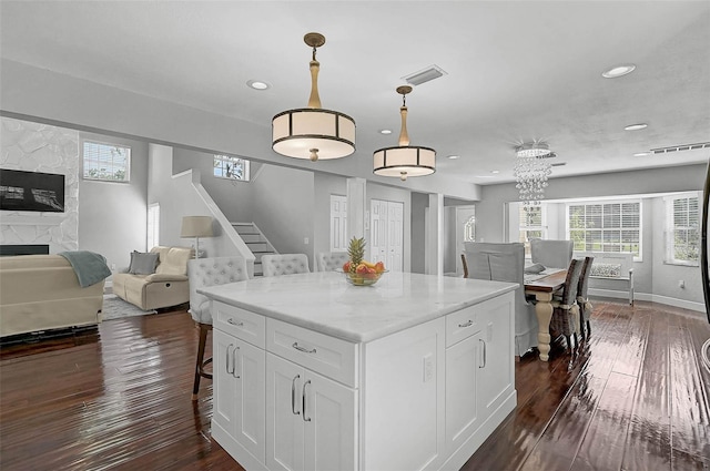 13514 4th Plz E, Bradenton, FL 34212 - kitchen featuring dark wood-style floors, white cabinetry, recessed lighting, a fireplace, and a center island