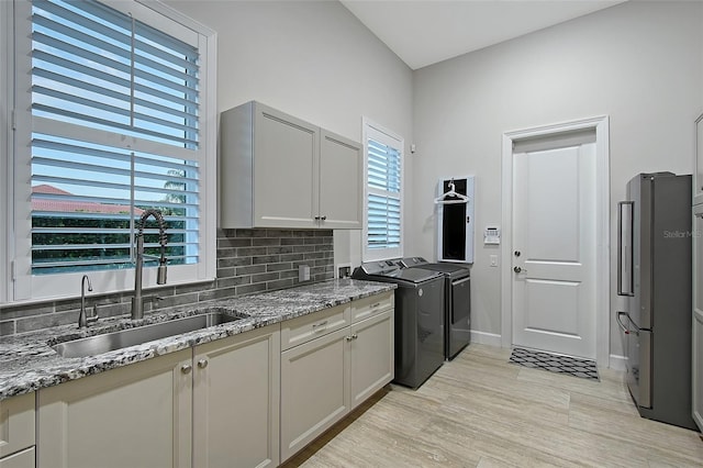 22343 Panther Loop, Bradenton, FL 34202 - kitchen with independent washer and dryer, freestanding refrigerator, tasteful backsplash, light stone countertops, and plenty of natural light