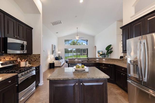 12031 Longview Lake Cir, Lakewood Ranch, FL 34211 - kitchen featuring appliances with stainless steel finishes, a ceiling fan, vaulted ceiling, light stone counters, and open floor plan