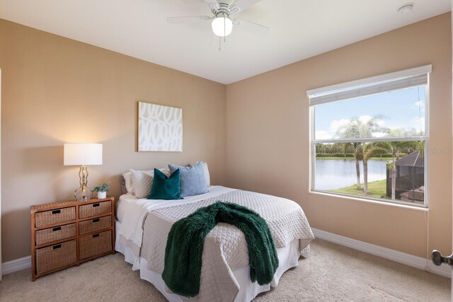 12031 Longview Lake Cir, Lakewood Ranch, FL 34211 - bedroom with light carpet, baseboards, multiple windows, and a water view