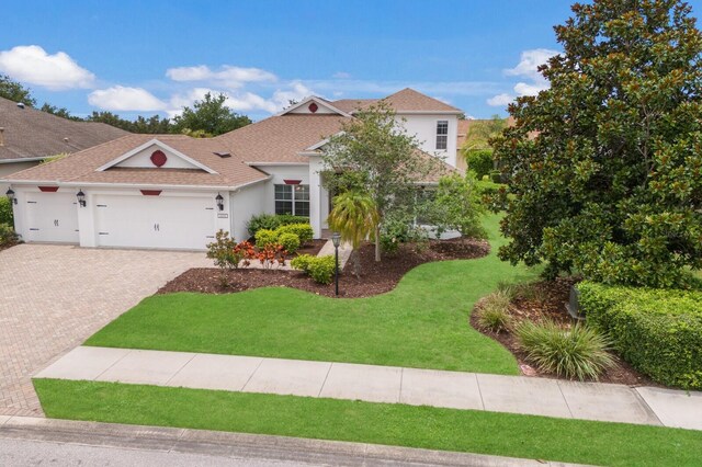 12031 Longview Lake Cir, Lakewood Ranch, FL 34211 - view of front of home featuring stucco siding, a garage, a front yard, driveway, and roof with shingles