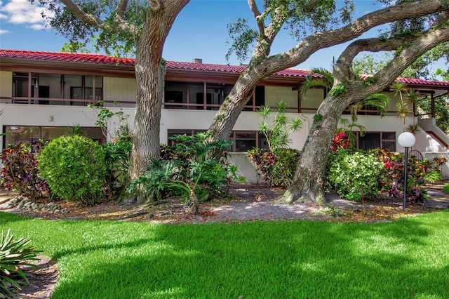3500 El Conquistador Pkwy Unit 128, Bradenton, FL 34210 - rear view of house featuring stucco siding, a tiled roof, and a yard