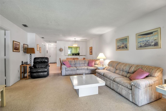 3500 El Conquistador Pkwy Unit 128, Bradenton, FL 34210 - living room with a chandelier, light colored carpet, and a textured ceiling