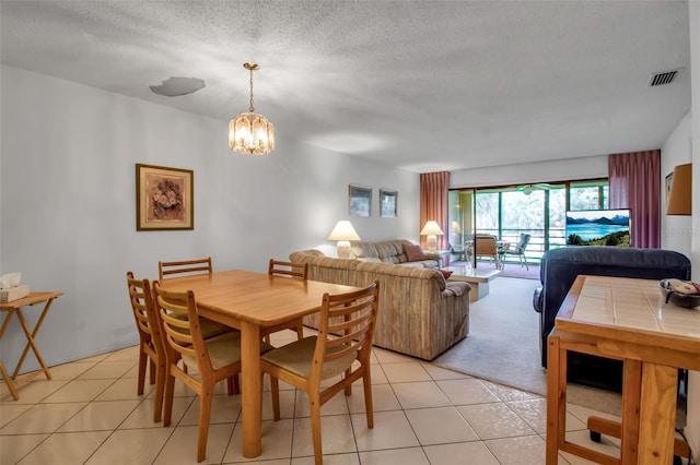 3500 El Conquistador Pkwy Unit 128, Bradenton, FL 34210 - dining space with a chandelier, light tile patterned floors, and a textured ceiling