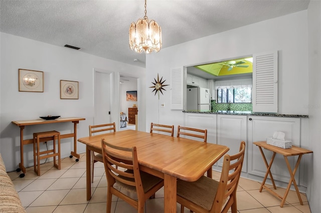 3500 El Conquistador Pkwy Unit 128, Bradenton, FL 34210 - dining area with a chandelier, light tile patterned floors, a textured ceiling, and ceiling fan