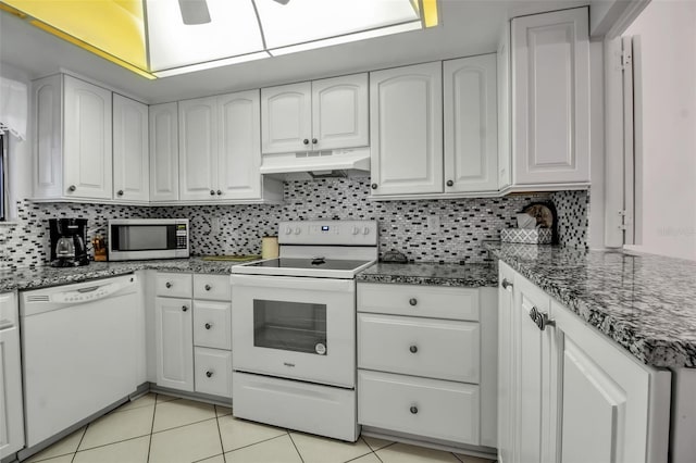 3500 El Conquistador Pkwy Unit 128, Bradenton, FL 34210 - kitchen with white appliances, under cabinet range hood, white cabinetry, and light tile patterned floors