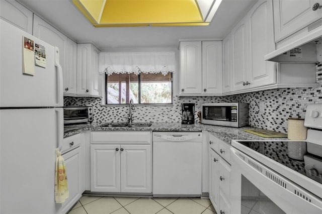 3500 El Conquistador Pkwy Unit 128, Bradenton, FL 34210 - kitchen with white appliances, under cabinet range hood, white cabinetry, and backsplash