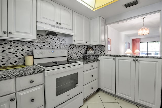 3500 El Conquistador Pkwy Unit 128, Bradenton, FL 34210 - kitchen with electric range, under cabinet range hood, white cabinets, dark stone countertops, and tasteful backsplash