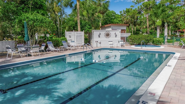 3500 El Conquistador Pkwy Unit 128, Bradenton, FL 34210 - community pool with a community hot tub, view of wooded area, and a patio