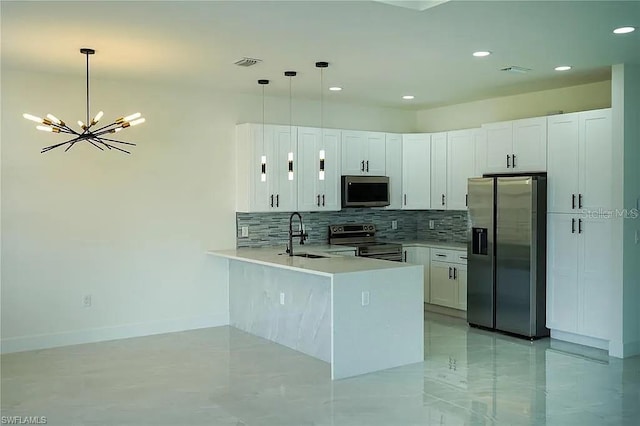 3017 4th St W, Lehigh Acres, FL 33971 - kitchen featuring stainless steel appliances, a sink, a peninsula, tasteful backsplash, and a chandelier