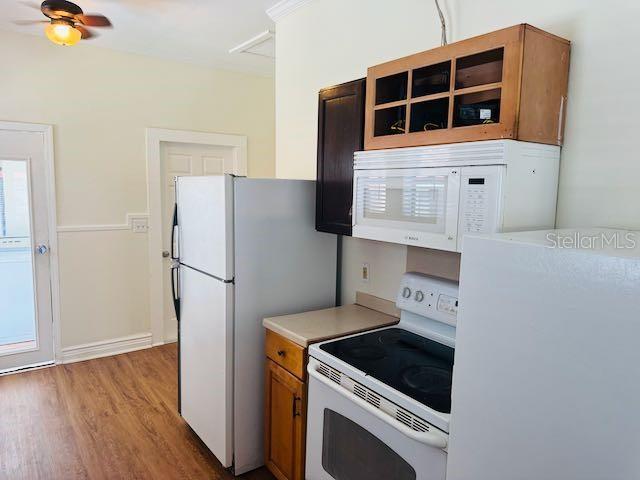 1412 12th Ave W, Bradenton, FL 34205 - kitchen with white appliances, light wood-style flooring, brown cabinetry, light countertops, and ceiling fan