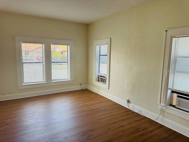 1412 12th Ave W, Bradenton, FL 34205 - spare room with dark wood finished floors, baseboards, and cooling unit