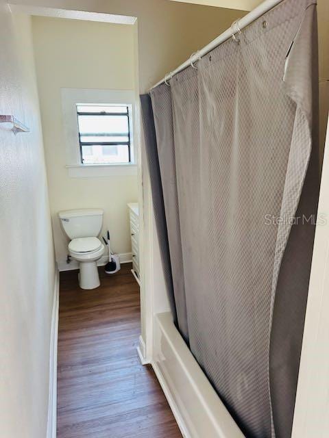 1412 12th Ave W, Bradenton, FL 34205 - bathroom with wood finished floors, toilet, baseboards, and shower / bath combo