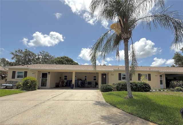 390 301st Blvd W Unit 2C, Bradenton, FL 34205 - ranch-style home with stucco siding, concrete driveway, a front yard, and an attached carport