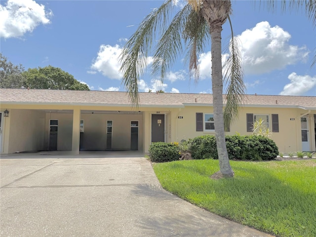 390 301st Blvd W Unit 2C, Bradenton, FL 34205 - ranch-style home featuring stucco siding, concrete driveway, a front yard, and an attached carport