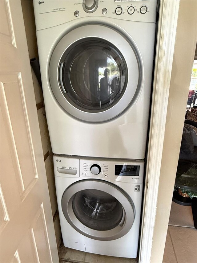 390 301st Blvd W Unit 2C, Bradenton, FL 34205 - washroom featuring stacked washer / dryer and tile patterned flooring