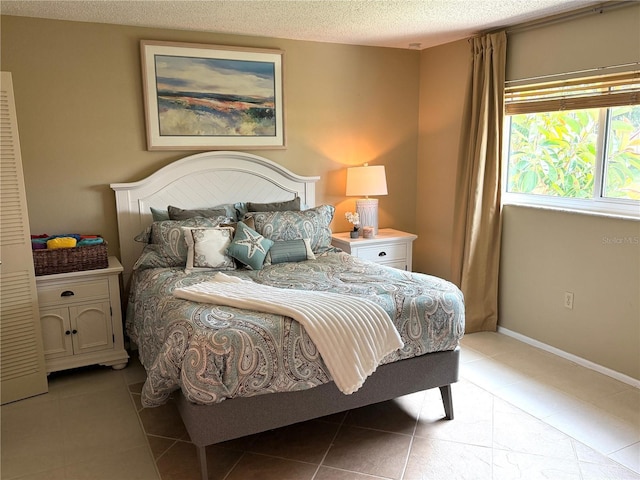 390 301st Blvd W Unit 2C, Bradenton, FL 34205 - bedroom featuring light tile patterned floors and a textured ceiling
