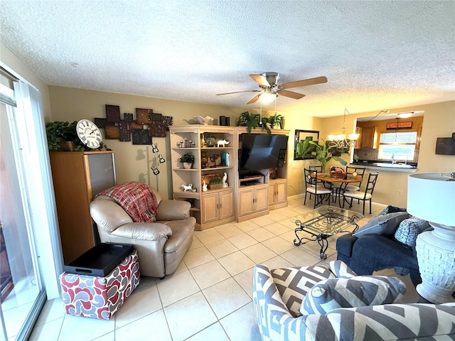 390 301st Blvd W Unit 2C, Bradenton, FL 34205 - living room featuring light tile patterned floors, ceiling fan, a textured ceiling, and a chandelier