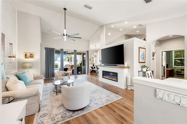 6750 64th Ter E, Bradenton, FL 34203 - living room featuring arched walkways, a glass covered fireplace, ceiling fan, recessed lighting, and light wood-style flooring