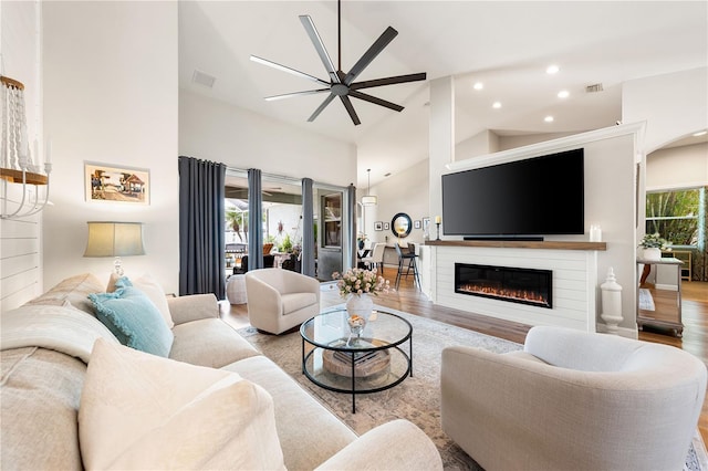 6750 64th Ter E, Bradenton, FL 34203 - living area with ceiling fan, wood finished floors, high vaulted ceiling, a glass covered fireplace, and recessed lighting