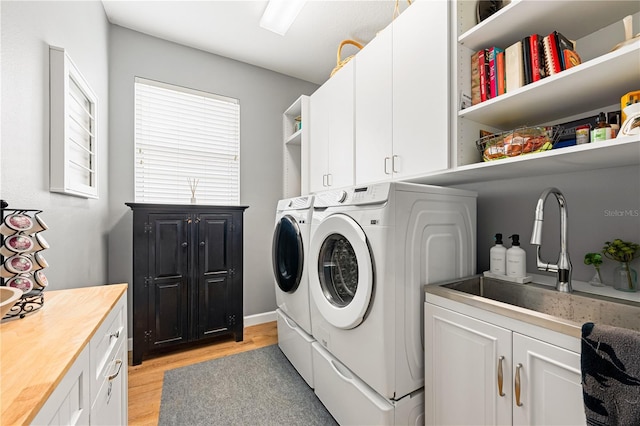 6750 64th Ter E, Bradenton, FL 34203 - laundry area featuring washer and clothes dryer, light wood-style flooring, and cabinet space