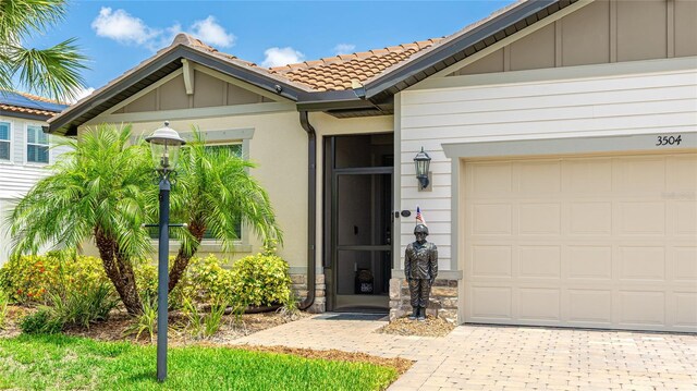 3504 Big Sky Way, Bradenton, FL 34211 - entrance to property featuring a tiled roof, stone siding, board and batten siding, and driveway