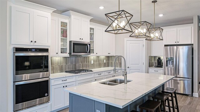 3504 Big Sky Way, Bradenton, FL 34211 - kitchen with stainless steel appliances, a sink, white cabinetry, a kitchen breakfast bar, and recessed lighting