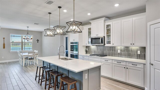 3504 Big Sky Way, Bradenton, FL 34211 - kitchen with a sink, appliances with stainless steel finishes, a chandelier, tasteful backsplash, and light wood finished floors