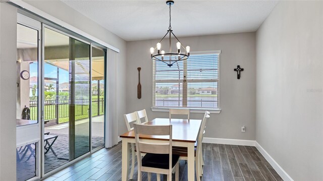 3504 Big Sky Way, Bradenton, FL 34211 - dining area with dark wood-style flooring, a chandelier, and baseboards