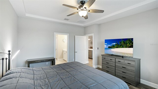 3504 Big Sky Way, Bradenton, FL 34211 - bedroom featuring a raised ceiling, baseboards, wood finished floors, ceiling fan, and ensuite bathroom