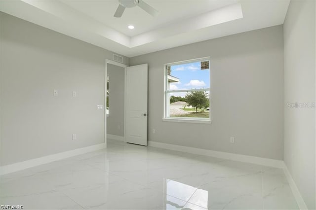 2906 18th St SW, Lehigh Acres, FL 33976 - spare room with light marble finish flooring, baseboards, a tray ceiling, ceiling fan, and recessed lighting