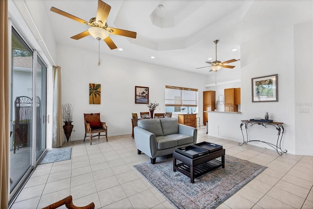 2085 Mattamy Ct, Venice, FL 34292 - living room featuring a ceiling fan, light tile patterned flooring, recessed lighting, a raised ceiling, and a high ceiling