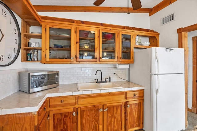 4528 58th St W, Bradenton, FL 34210 - kitchen featuring a sink, freestanding refrigerator, stainless steel microwave, tasteful backsplash, and open shelves
