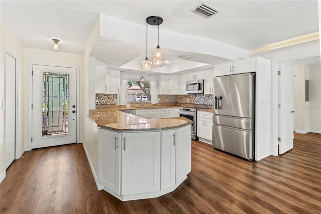 2515 Huntington Ave, Sarasota, FL 34232 - kitchen with appliances with stainless steel finishes, a peninsula, light stone countertops, white cabinetry, and tasteful backsplash
